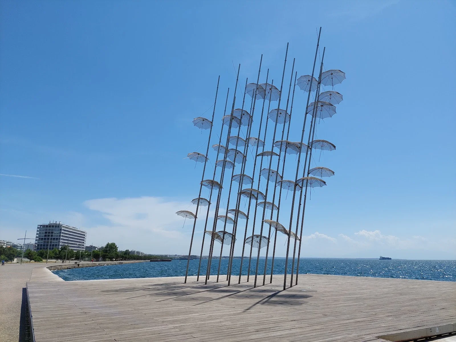The Umbrellas, George Zongolopoulos's steel sculpture, on the Nea Paralia waterfront in Thessaloniki against the blue Thermaic Gulf