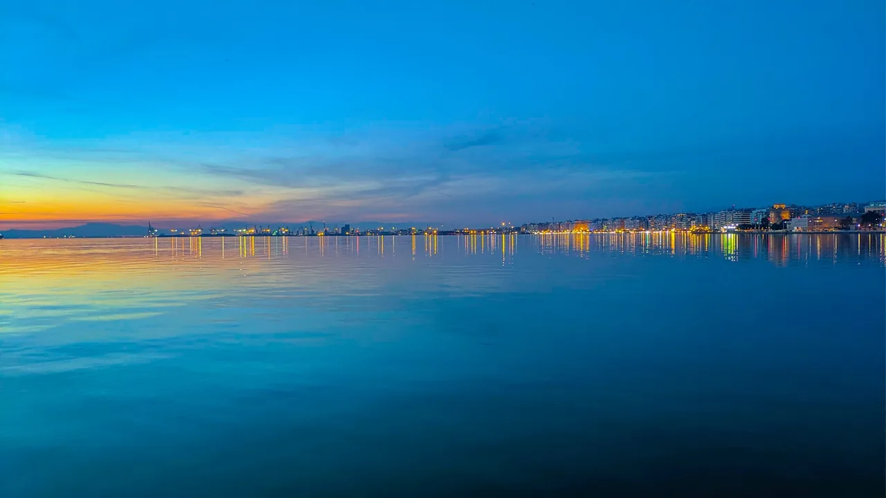 Thessaloniki's waterfront and city lights reflected on the Thermaic Gulf at blue hour