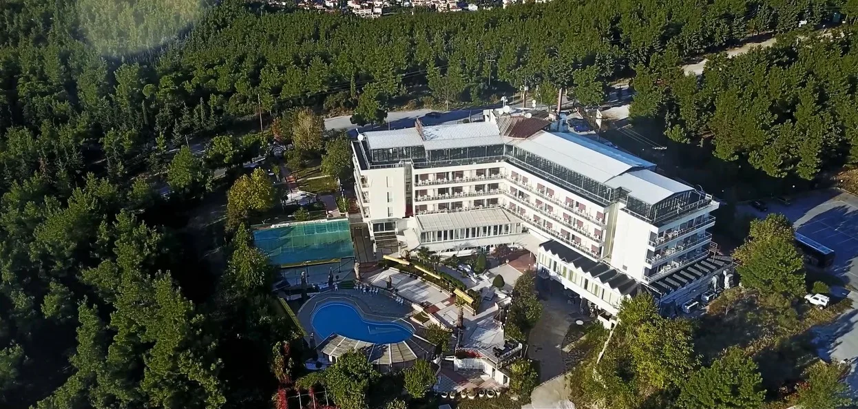 Aerial view of Hotel Philippion amid the pine forest above Thessaloniki with an outdoor pool and tennis court