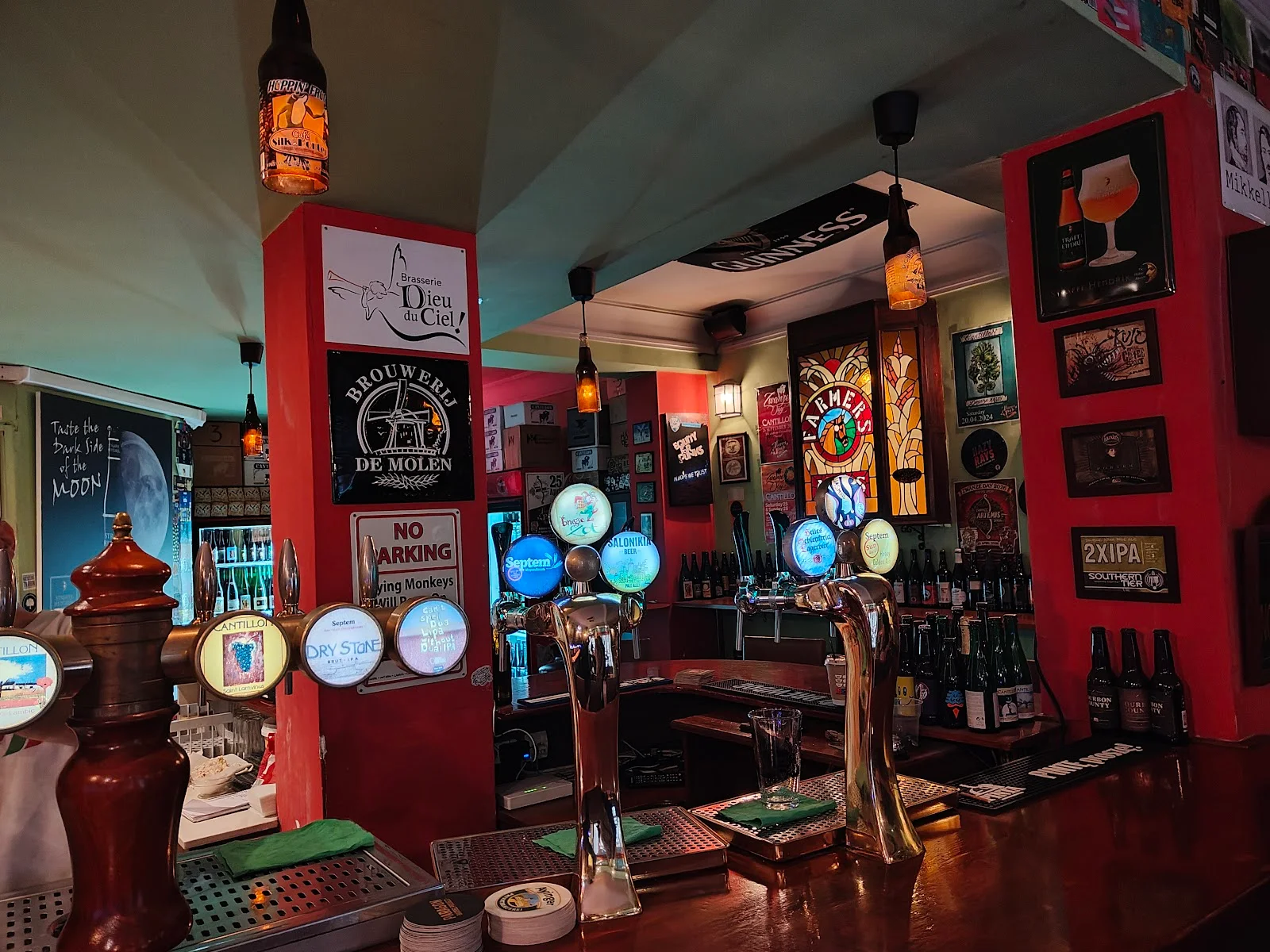 The bar and beer taps of The Hoppy Pub, a cosy craft-beer pub in central Thessaloniki, its walls lined with bottles