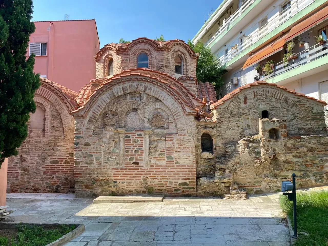 The brick-and-stone exterior of the Byzantine Bath in Ano Poli, Thessaloniki, with its arched recesses and domes