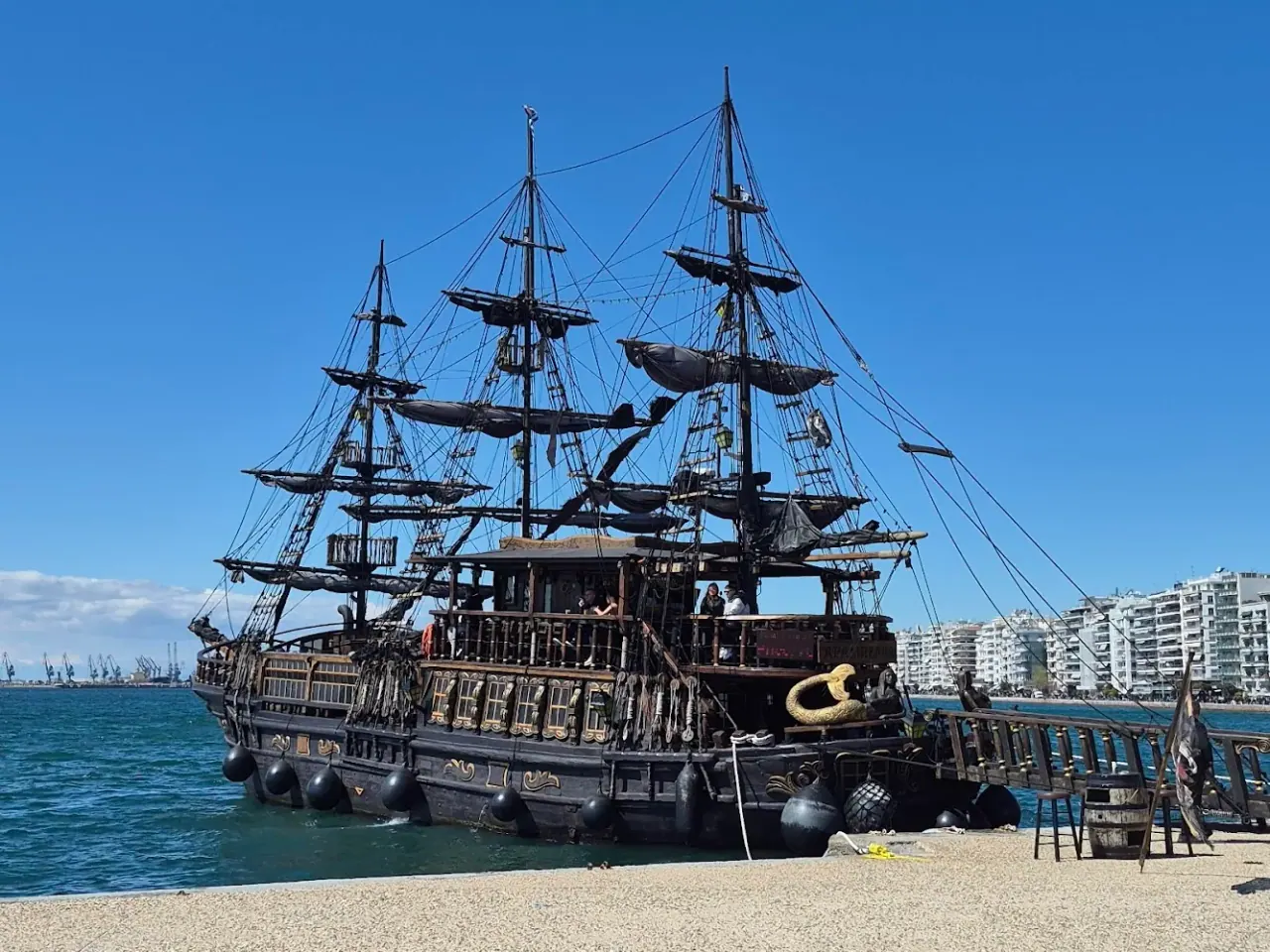 The Black Pearl pirate ship moored on the Thessaloniki waterfront, the city and gulf behind