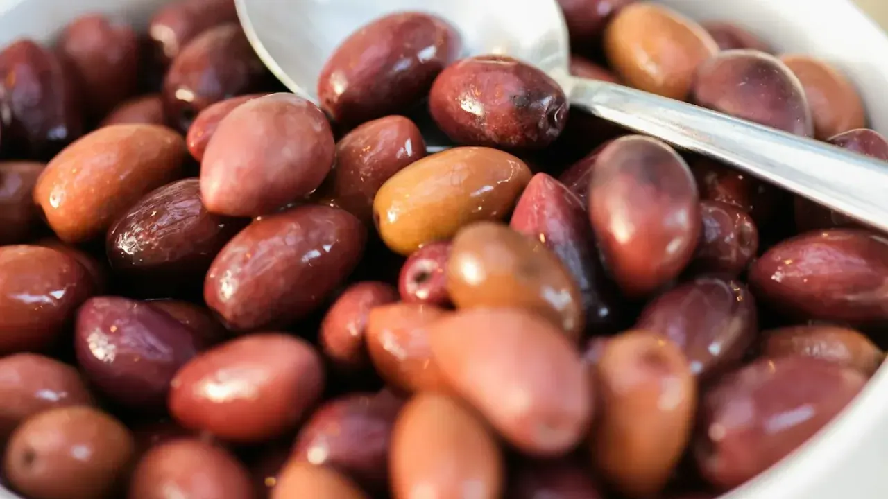 Stalls piled with olives, cheese and cured fish inside Thessaloniki's covered Kapani market