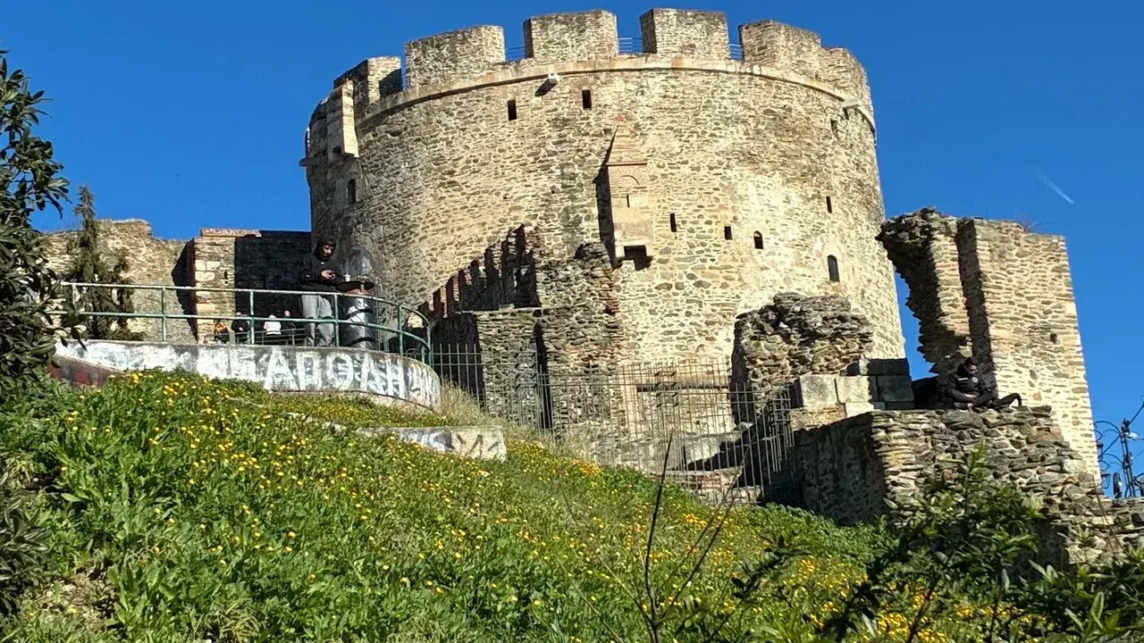 Spray-paint graffiti tags on the stone base of the Byzantine walls beside Trigonion Tower in Ano Poli, Thessaloniki