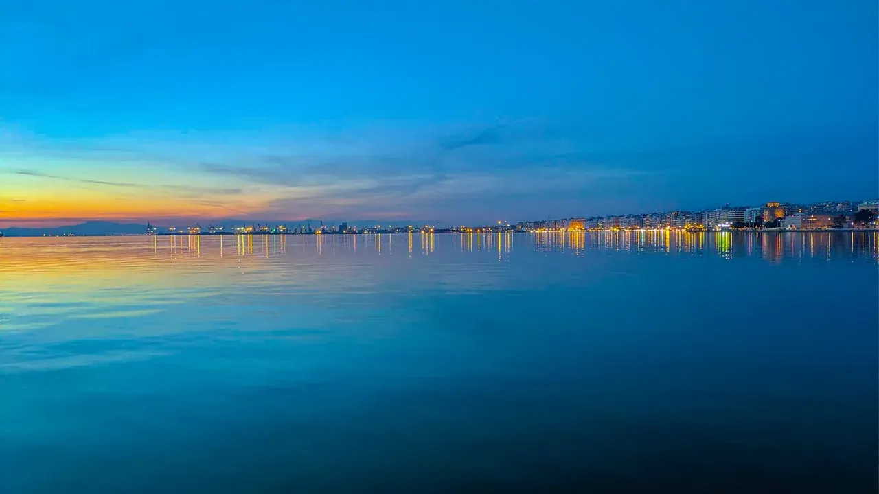 Thessaloniki's waterfront and city lights reflected on the Thermaic Gulf at blue hour