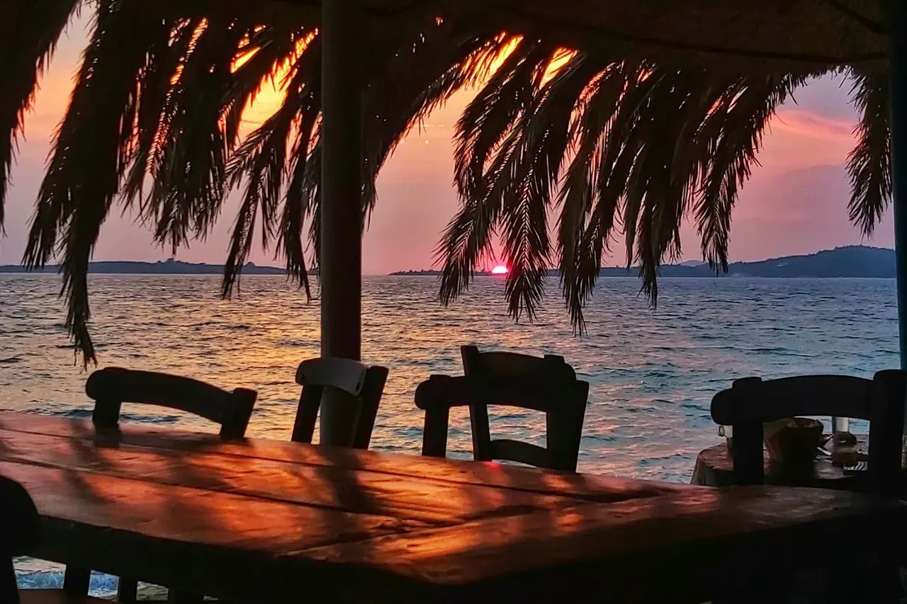 Sunset over the sea from a thatched beach bar in Halkidiki