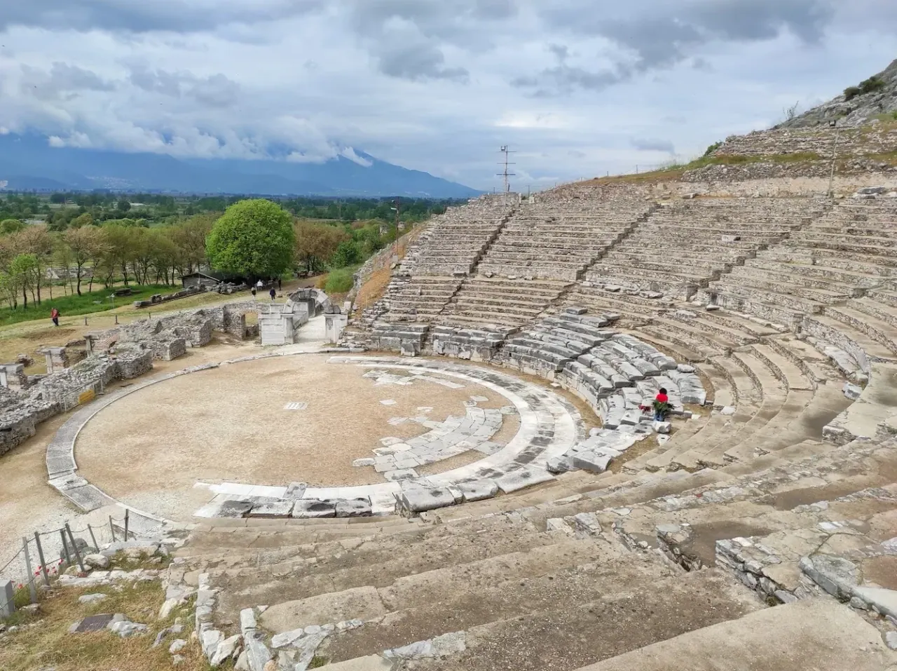 The ancient Roman theatre of Philippi with mountains rising behind it