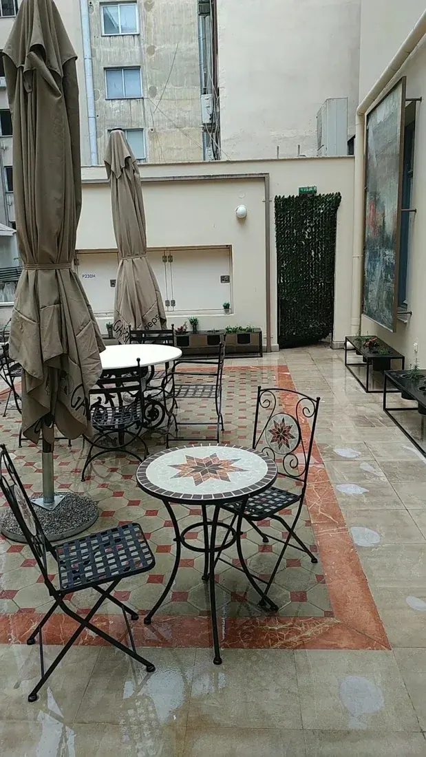 Inner courtyard of The Bristol Hotel with wrought-iron café tables on a mosaic-tiled floor