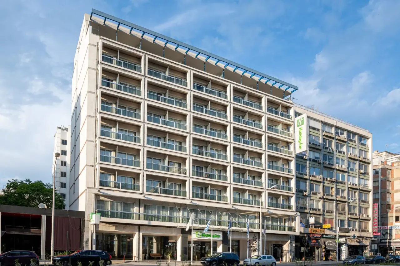 The balconied facade of Holiday Inn Thessaloniki with its green sign on Monastiriou Avenue