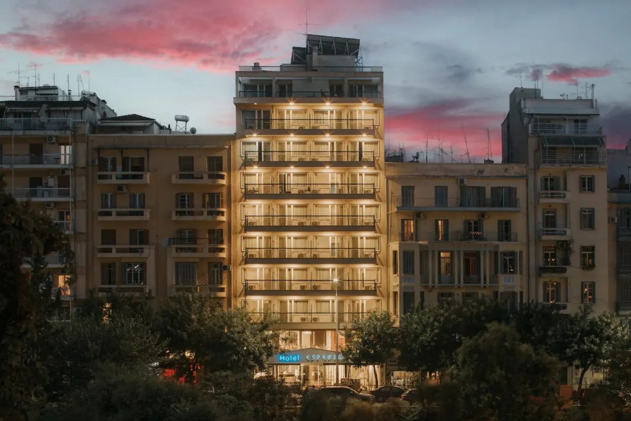 Hotel Esperia lit up at dusk with its blue sign in central Thessaloniki