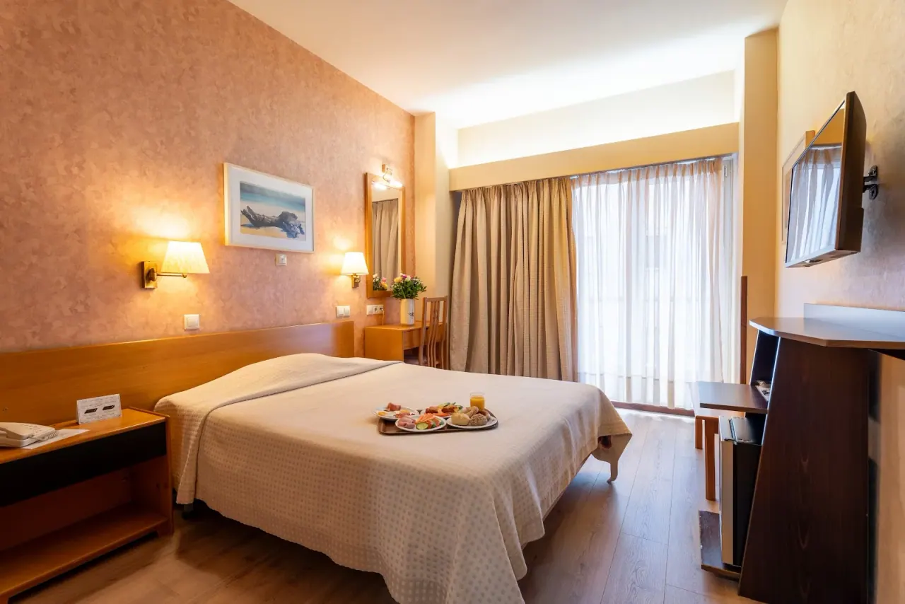 Warm-toned room with a breakfast tray at the Queen Olga Hotel, Thessaloniki