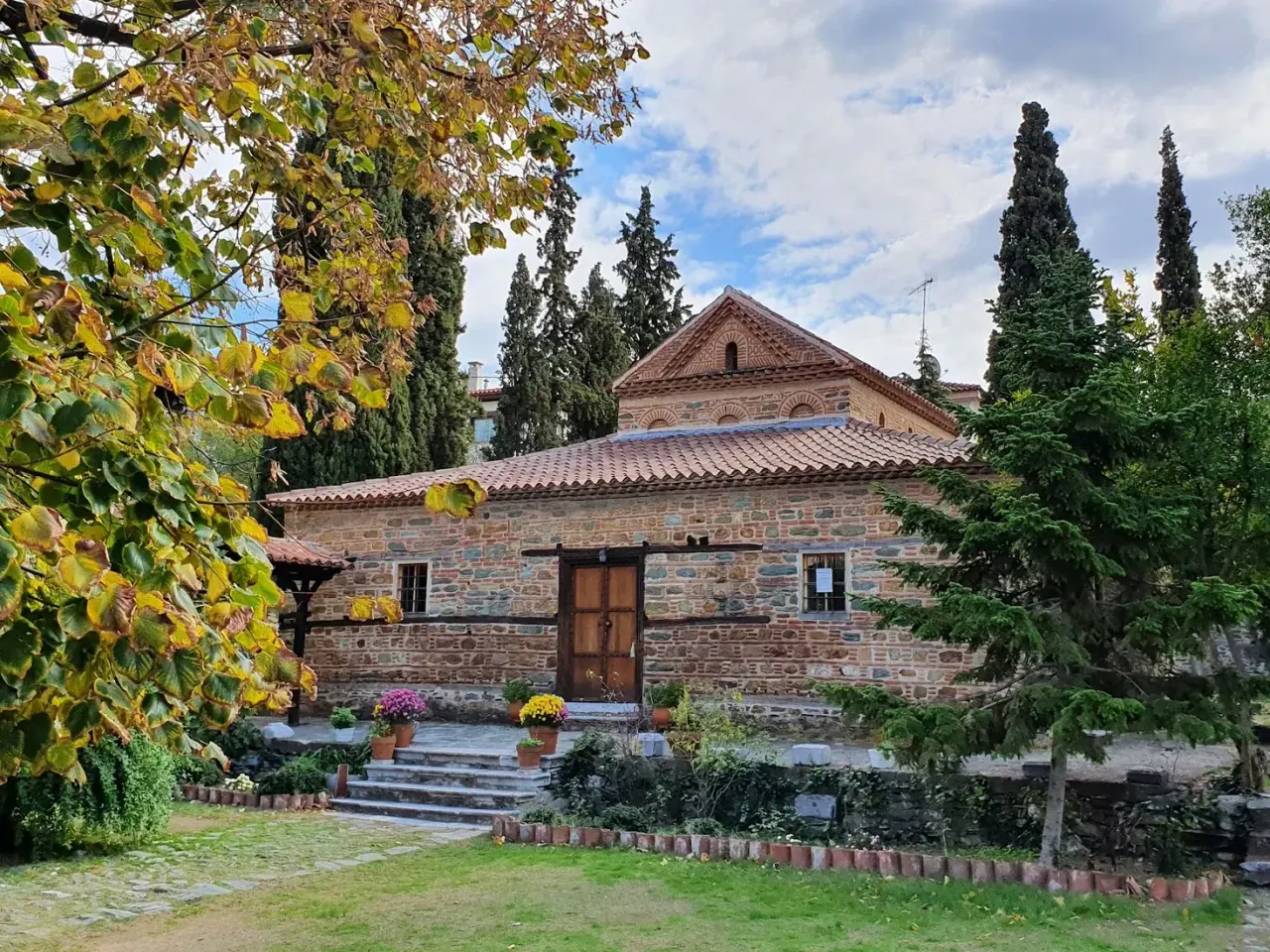 The small 14th-century stone church of Agios Nikolaos Orfanos in its garden in Ano Poli, Thessaloniki