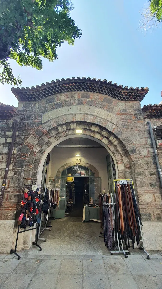 A brick arched entrance of the Bezesteni covered market with goods on display, Thessaloniki
