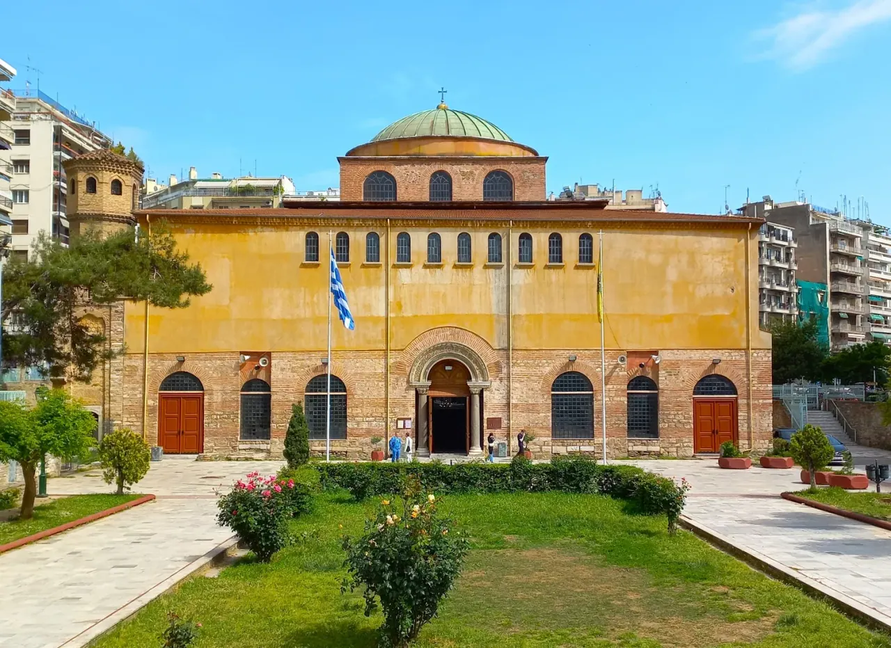 The ochre facade and lead dome of the Hagia Sophia church of Thessaloniki seen from its garden