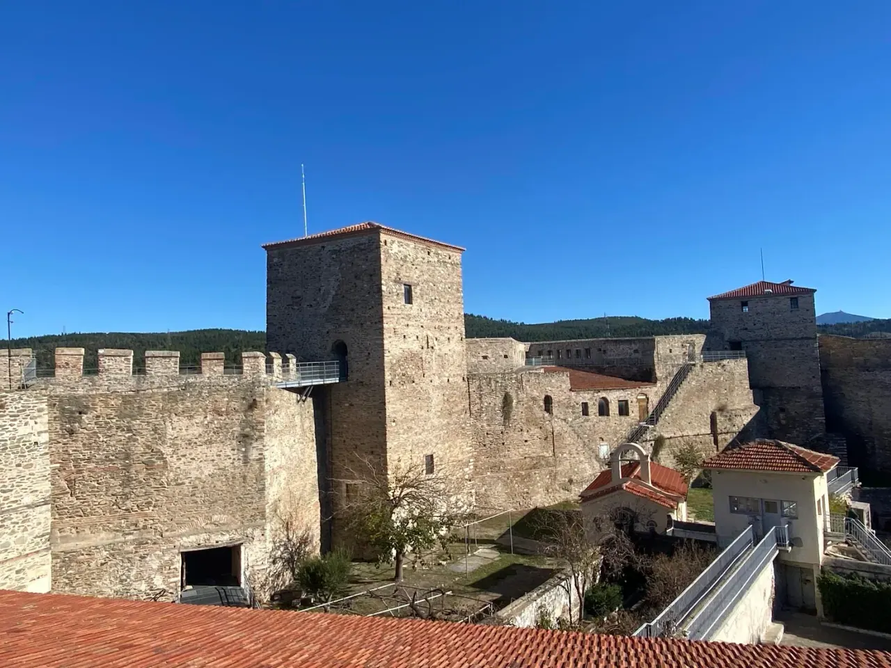 The walls, towers and courtyard of the Heptapyrgion fortress citadel above Thessaloniki under a blue sky