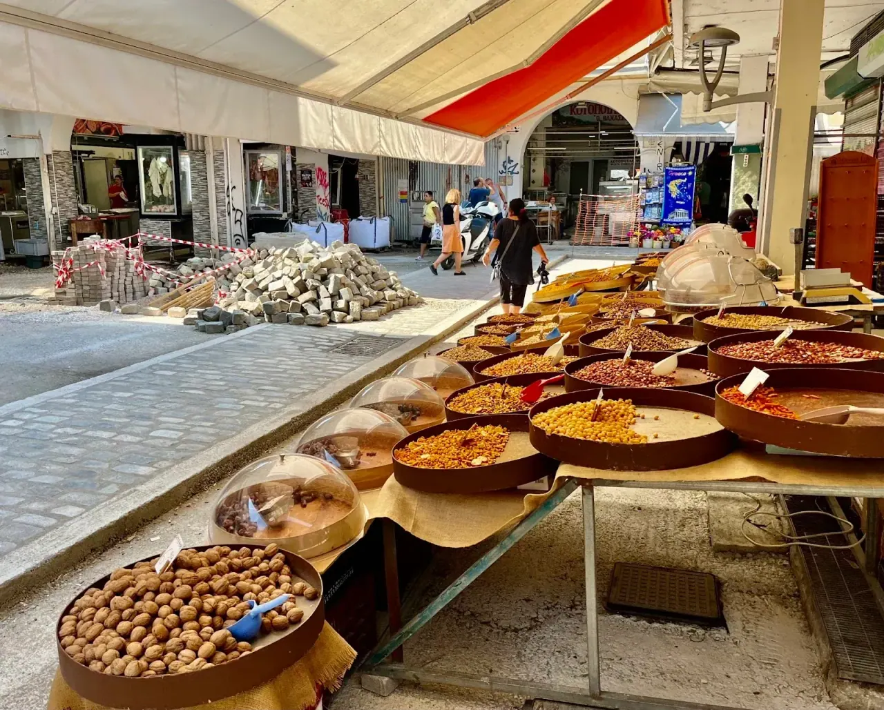 A long produce stall under the covered arcade of the Kapani market, Thessaloniki