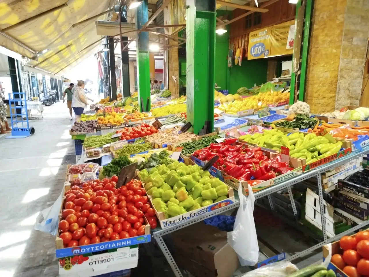 A fresh produce stall of peppers, tomatoes and greens inside the Modiano market