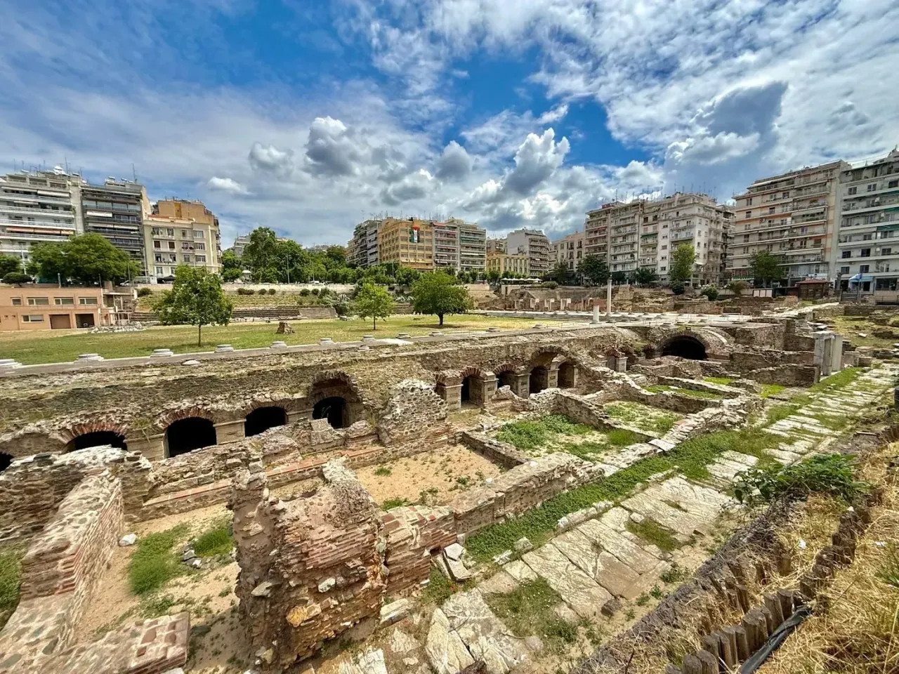 The excavated Roman Forum of Thessaloniki with standing columns and the modern city behind