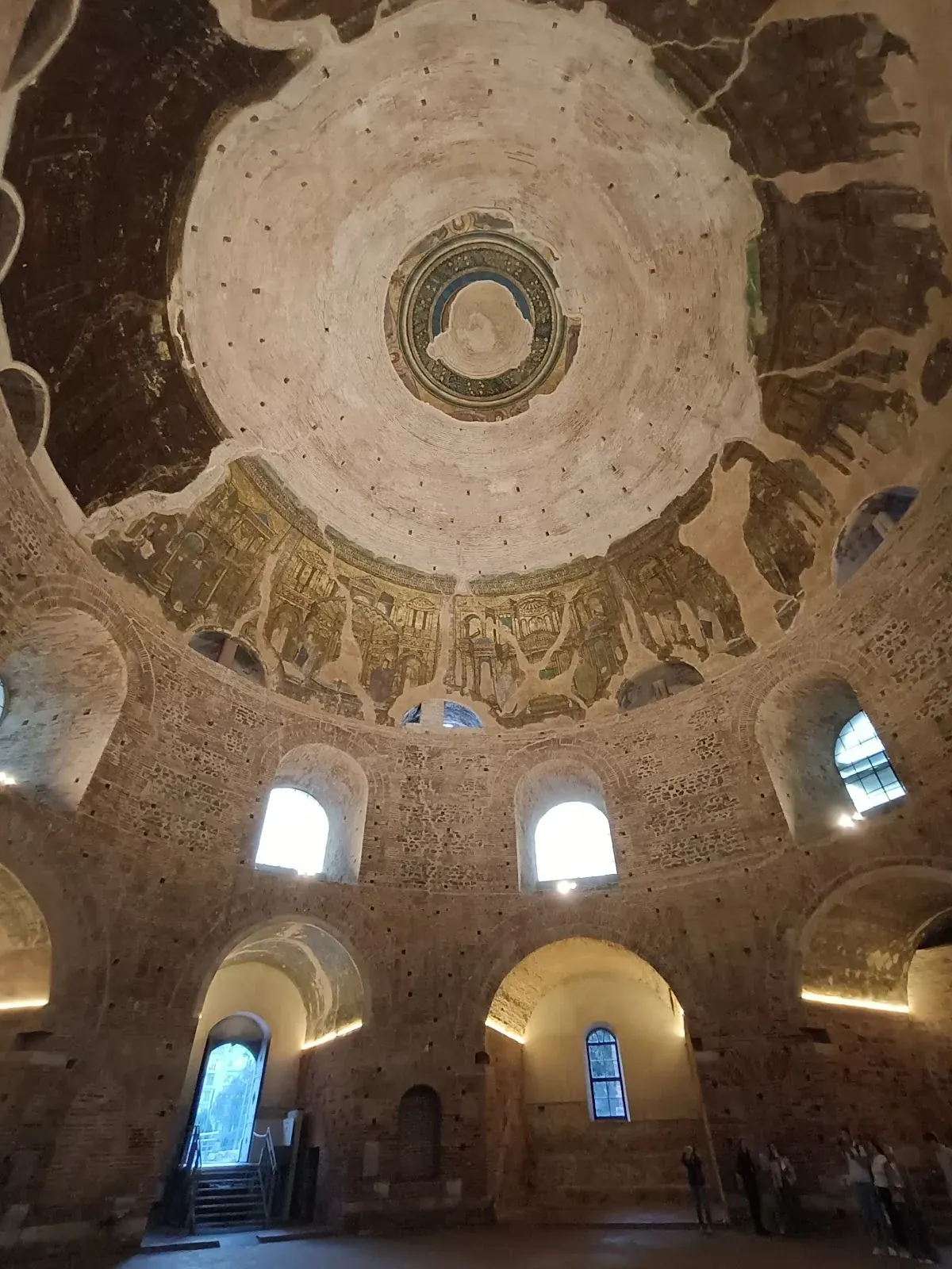 The vast brick dome of the Rotunda seen from inside, with surviving mosaics and arched windows