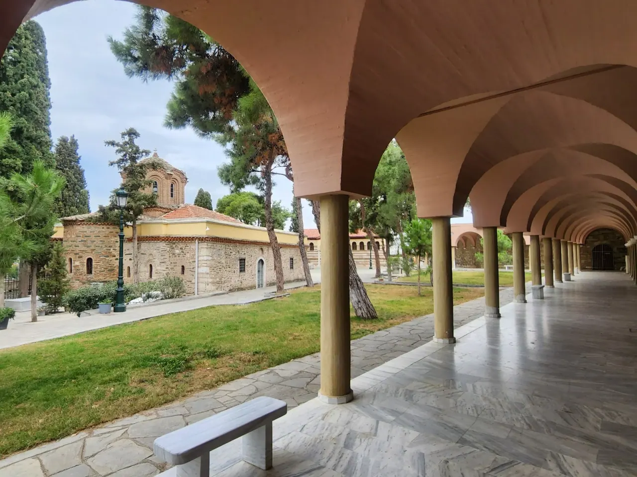 The arched colonnade of Vlatadon Monastery looking across the courtyard to the domed Byzantine church, Thessaloniki
