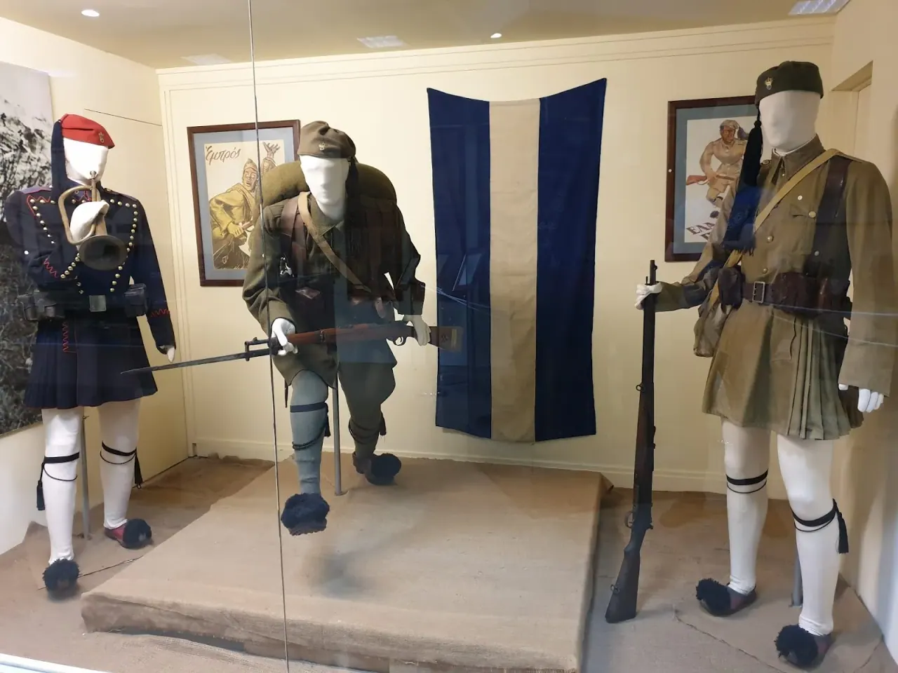 Historic Greek military uniforms, including an evzone, on display inside the War Museum of Thessaloniki