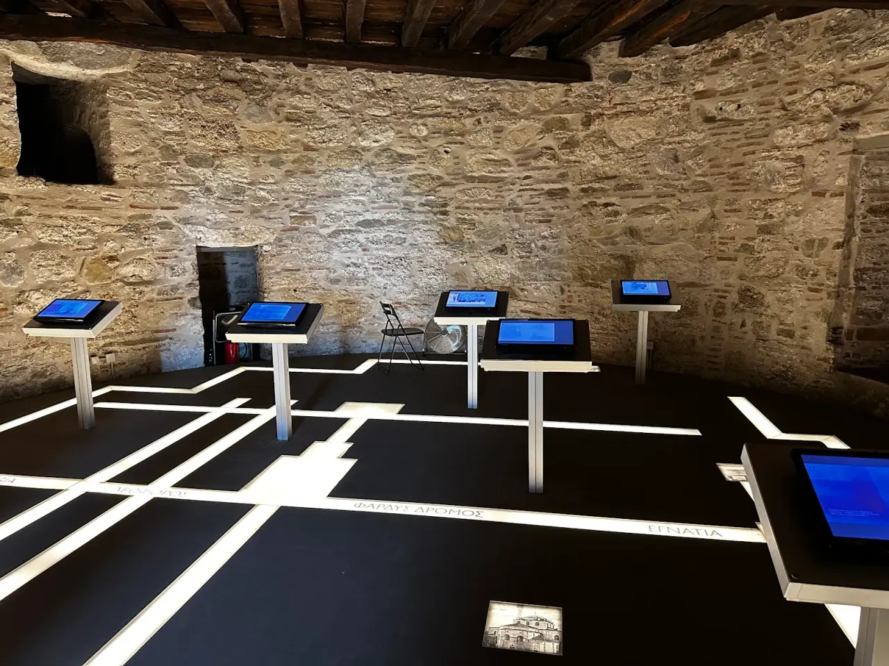 An exhibition room inside the White Tower museum, with interactive displays set against the medieval stone walls