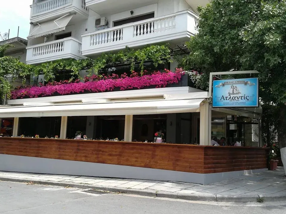 The bougainvillea-draped terrace and blue sign of Atlantis Fish Restaurant in Nea Krini, Kalamaria, Thessaloniki