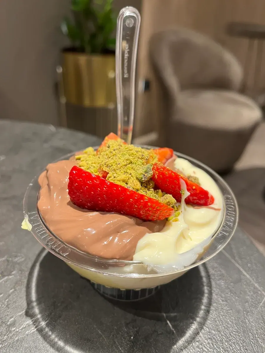 A Choureál cup of chocolate and vanilla cream topped with fresh strawberries and pistachio crumble, Thessaloniki