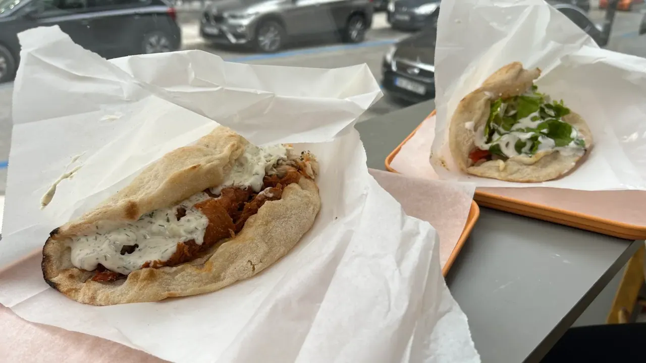 Two vegan gyros wraps in paper on a Handwich tray, filled with plant-based fillings and vegan tzatziki, Thessaloniki
