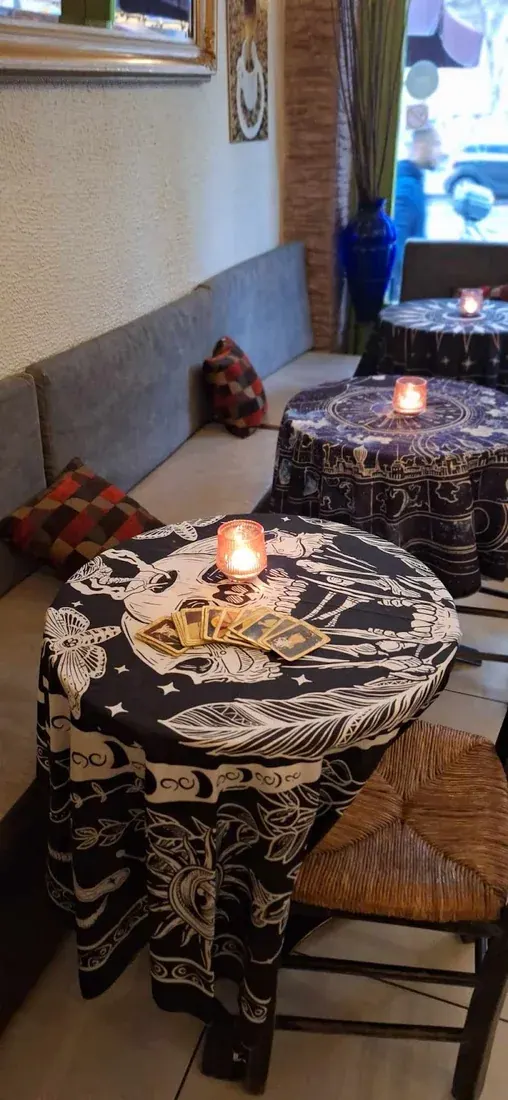 Candlelit tables with tarot-print cloths inside Kismet café-bar in Thessaloniki