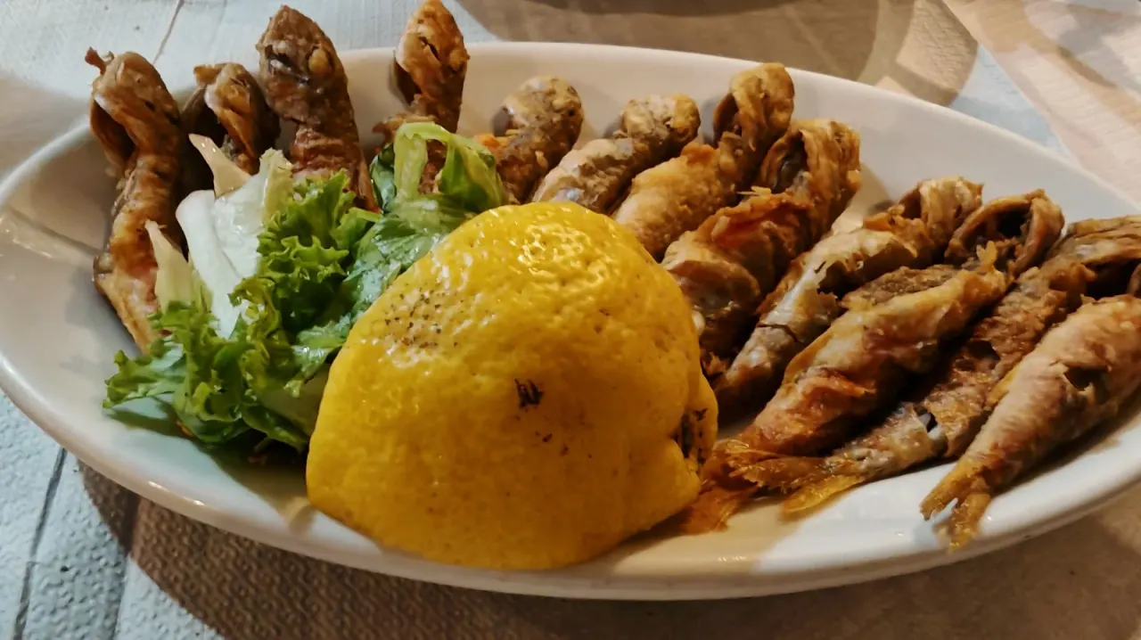 A plate of fried small fish with lemon and lettuce at Taverna Konaki, Ano Poli, Thessaloniki