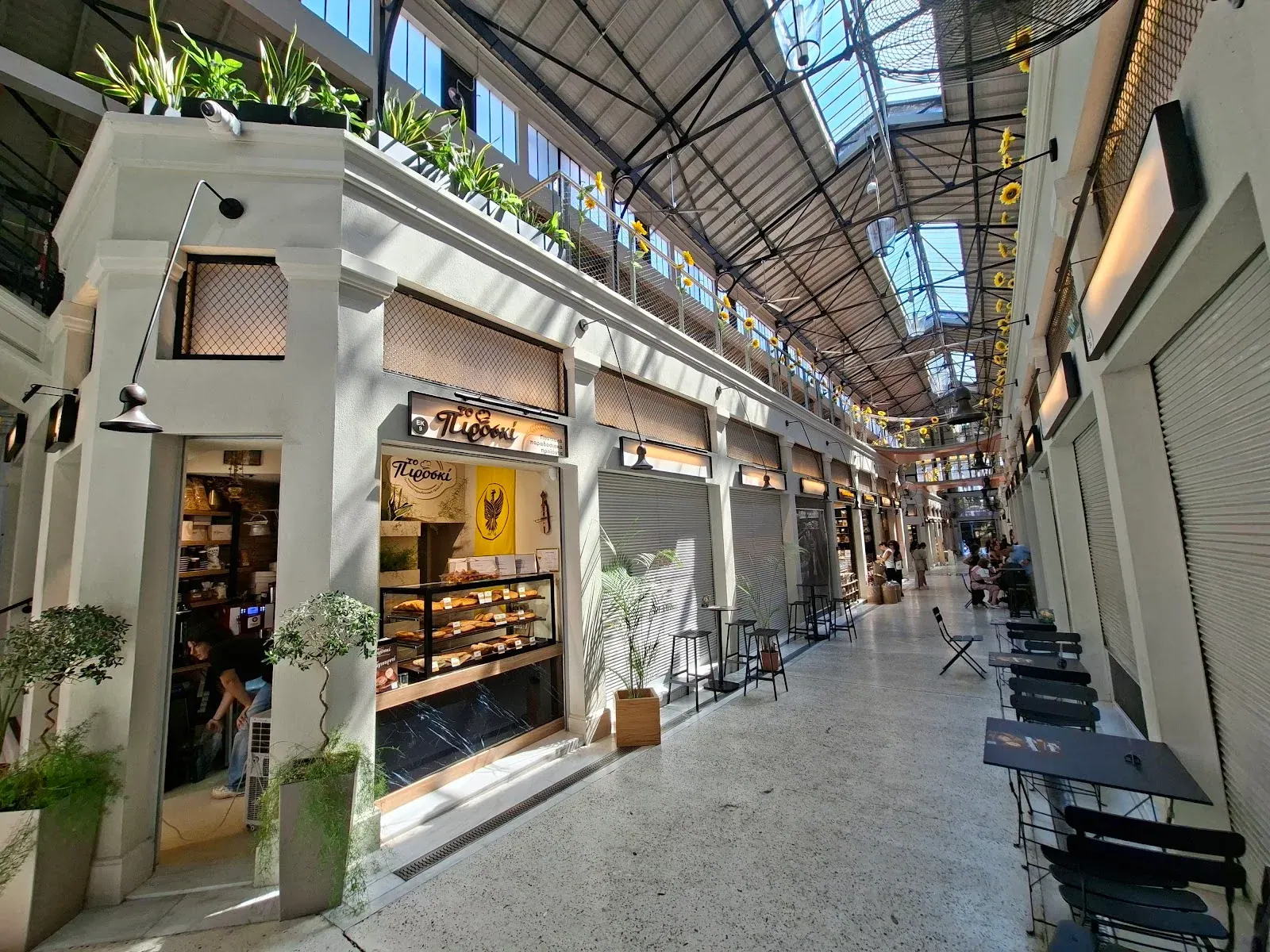 The restored glass-roofed arcade of Modiano Market in Thessaloniki, lined with food stalls