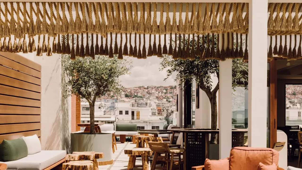 Boho-chic rooftop bar terrace with olive trees overlooking the Ano Poli hillside in Thessaloniki