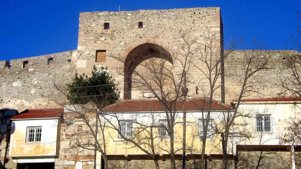 The stone walls and gatehouse of the Heptapyrgion fortress above Ano Poli, Thessaloniki, photographed in daytime light from one of the city's highest points