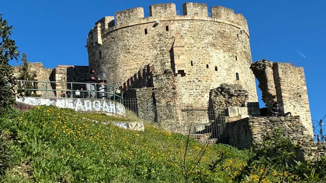 Spray-paint graffiti tags on the stone base of the Byzantine walls beside Trigonion Tower in Ano Poli, Thessaloniki