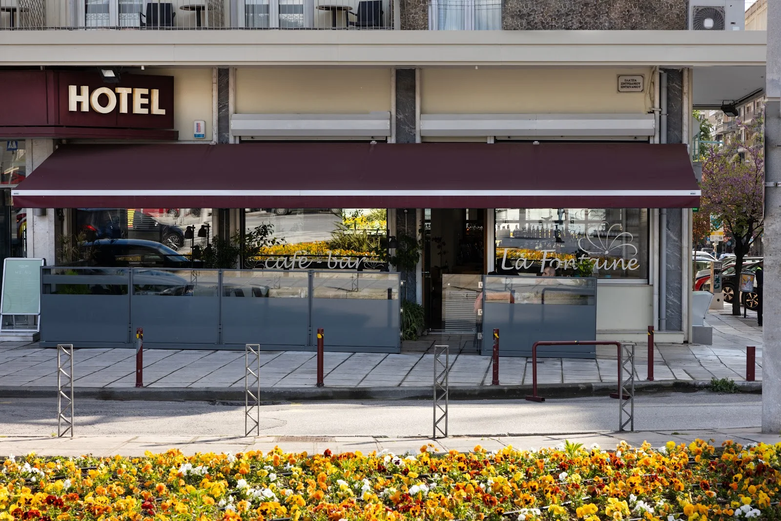 Entrance of ABC Hotel with its illuminated HOTEL sign and the La Fontaine café awning