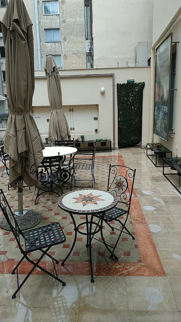 Inner courtyard of The Bristol Hotel with wrought-iron café tables on a mosaic-tiled floor