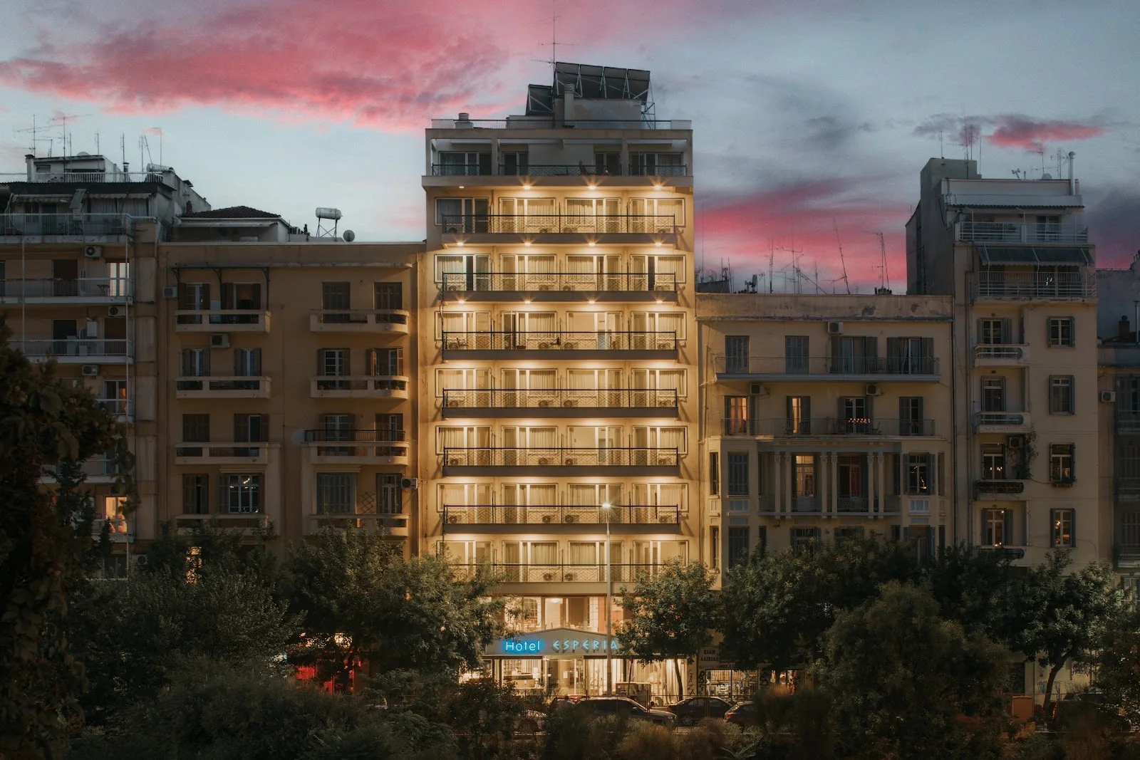 Hotel Esperia lit up at dusk with its blue sign in central Thessaloniki