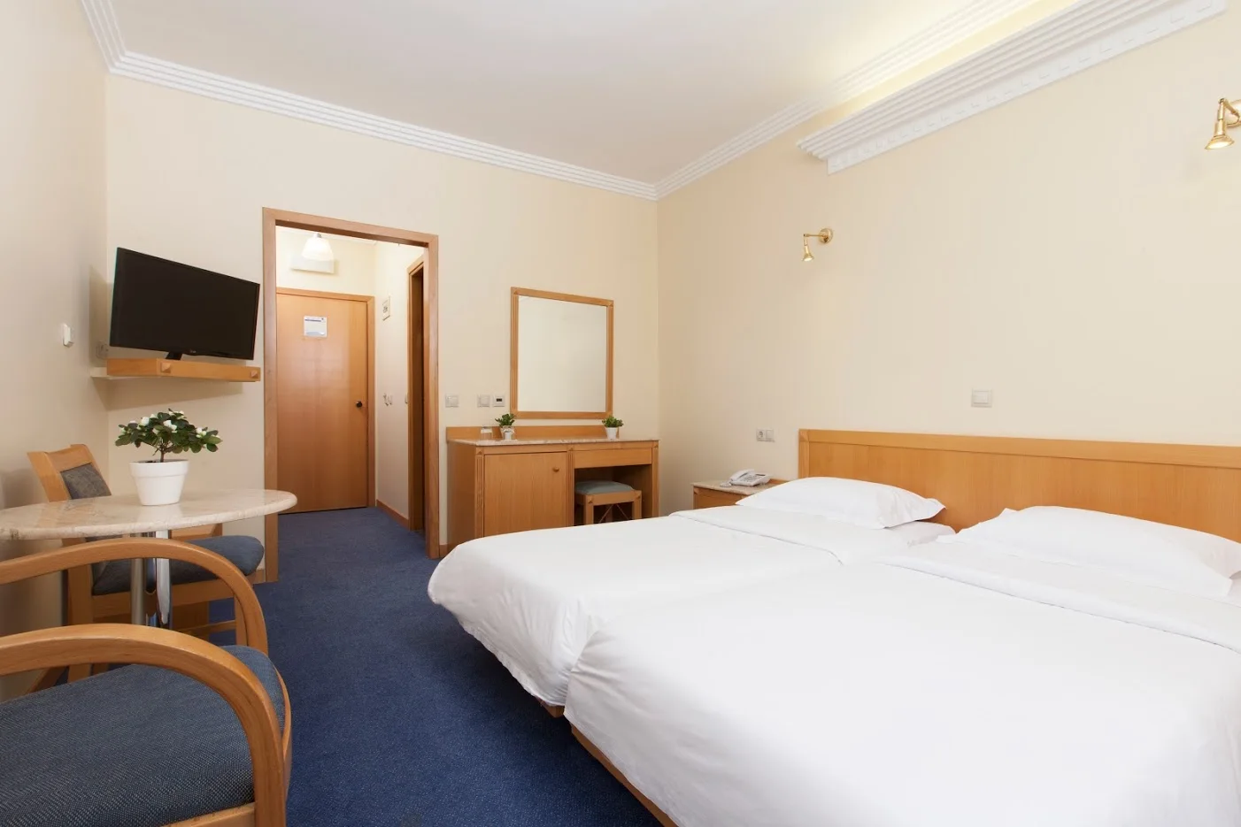 Bright twin room with a blue carpet at the Telioni Hotel, Thessaloniki