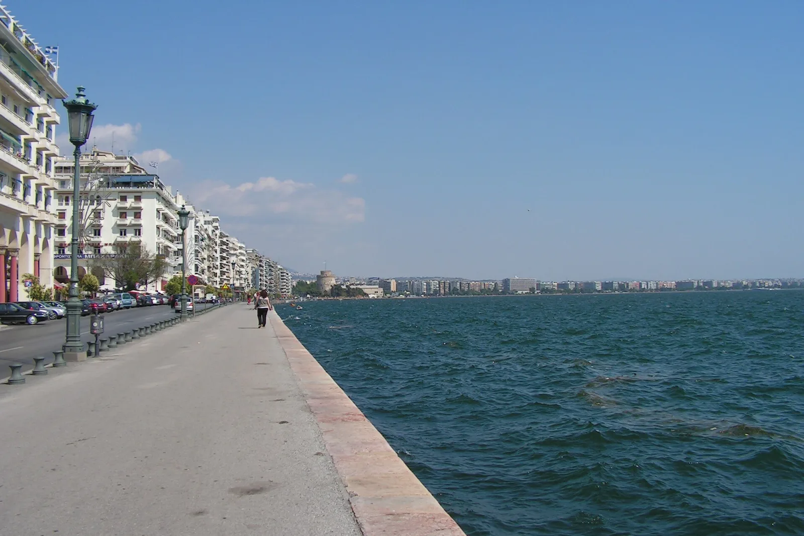 The seafront promenade of Thessaloniki curving toward the White Tower at dusk