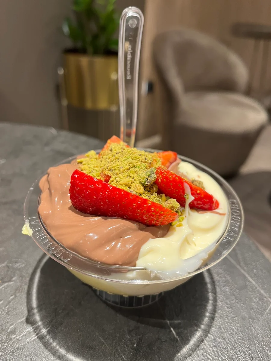 A Choureál cup of chocolate and vanilla cream topped with fresh strawberries and pistachio crumble, Thessaloniki