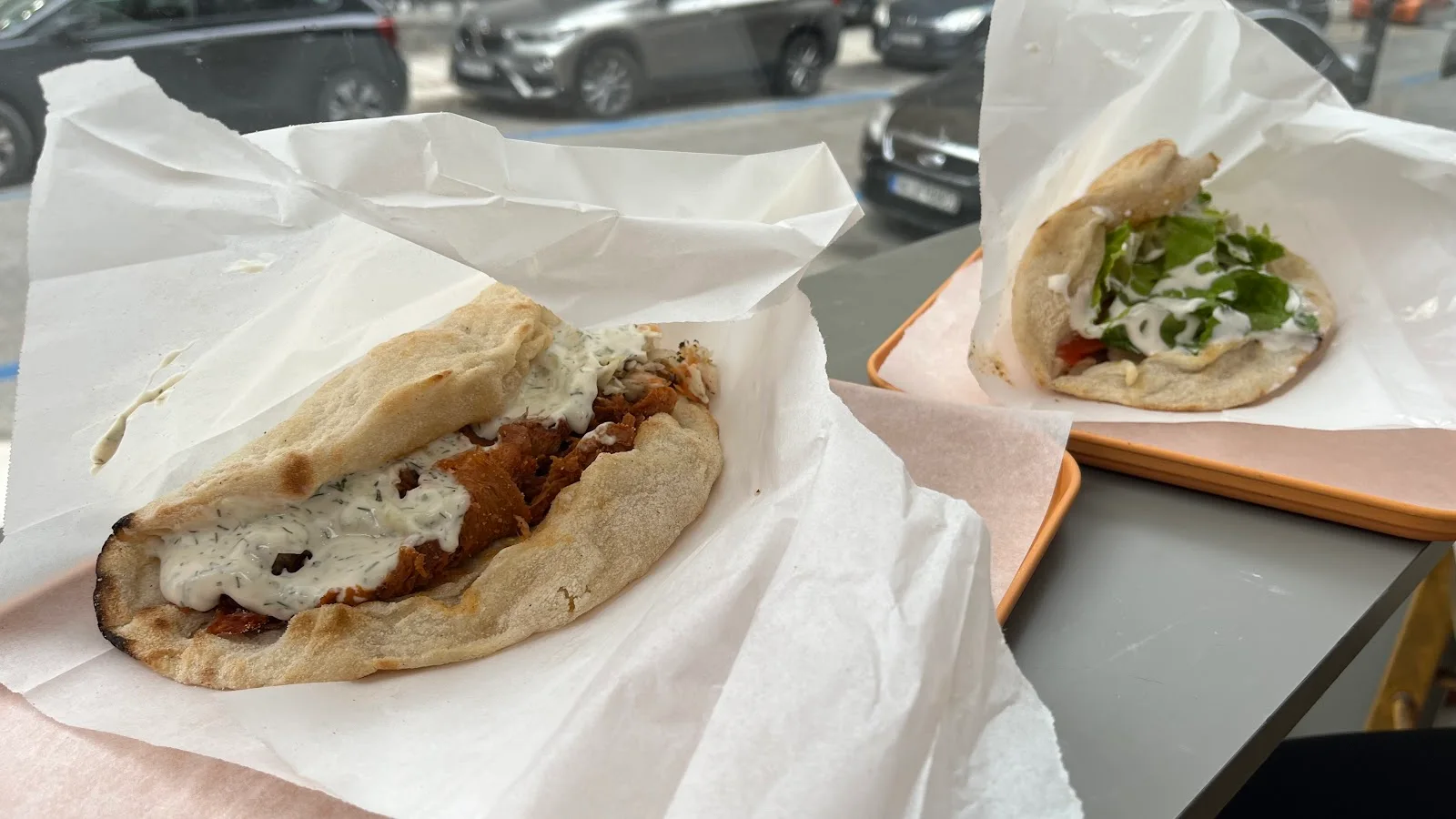 Two vegan gyros wraps in paper on a Handwich tray, filled with plant-based fillings and vegan tzatziki, Thessaloniki