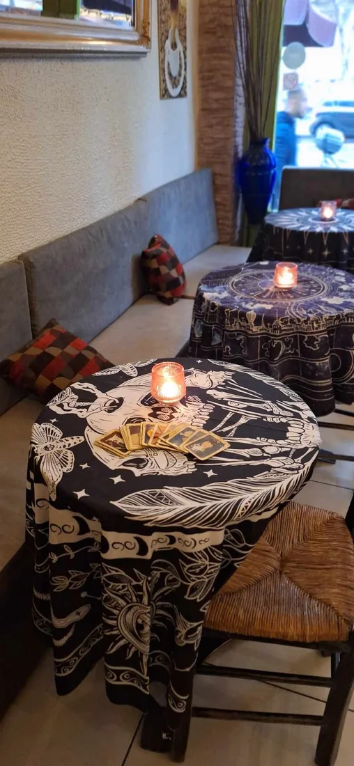 Candlelit tables with tarot-print cloths inside Kismet café-bar in Thessaloniki