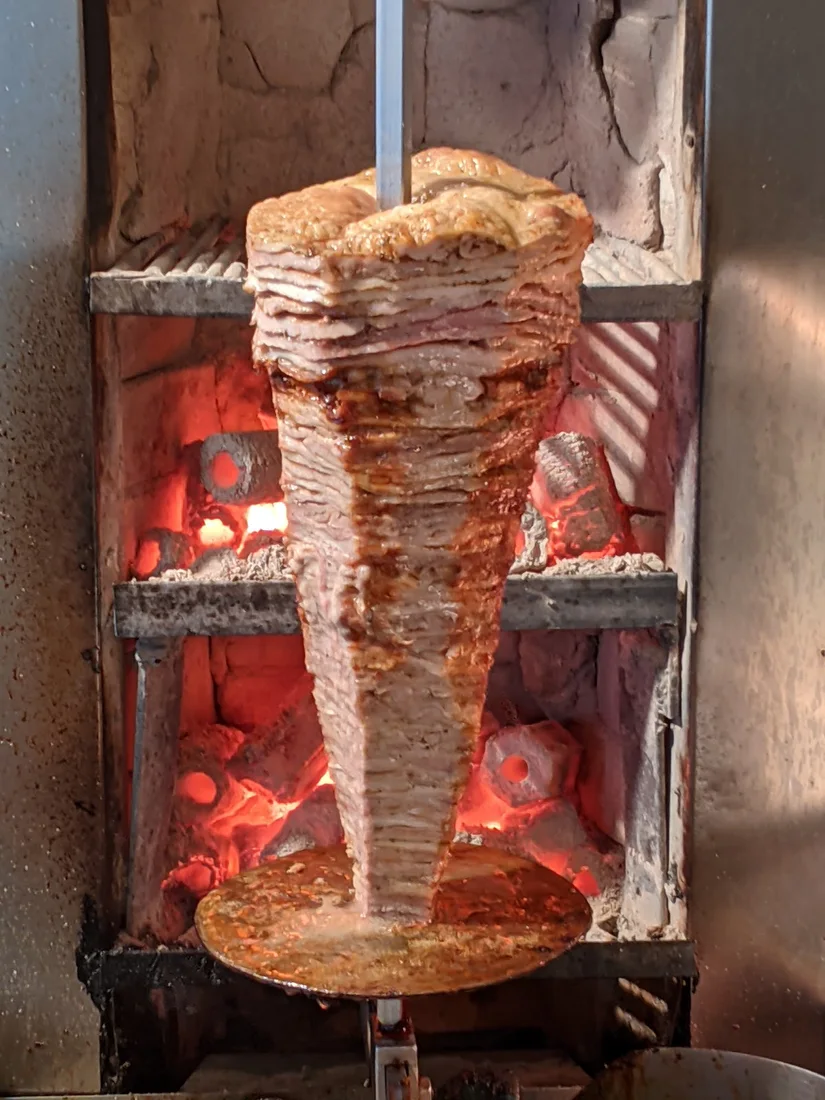 A gyros cone roasting over charcoal at Ta Adelfia grill house near the Kapani market, Thessaloniki