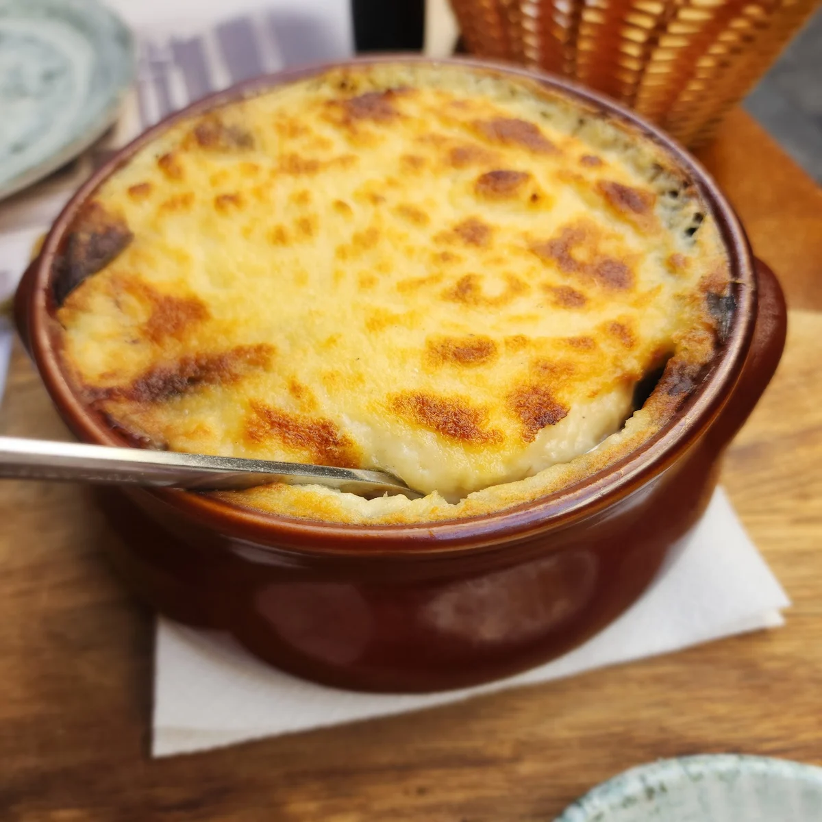 A golden-topped baked pastitsio in a terracotta pot at The Rouga, Thessaloniki