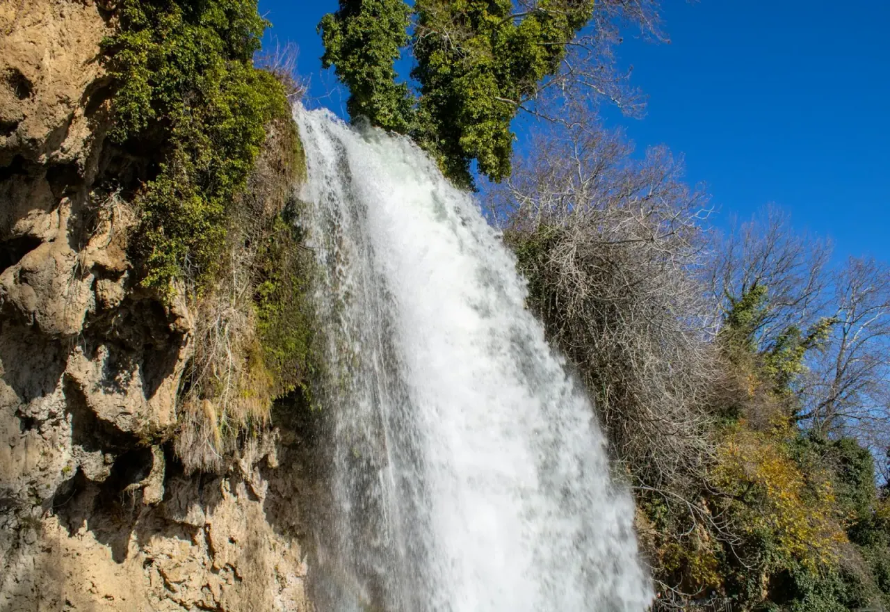 The Karanos waterfall plunging over a mossy cliff at Edessa