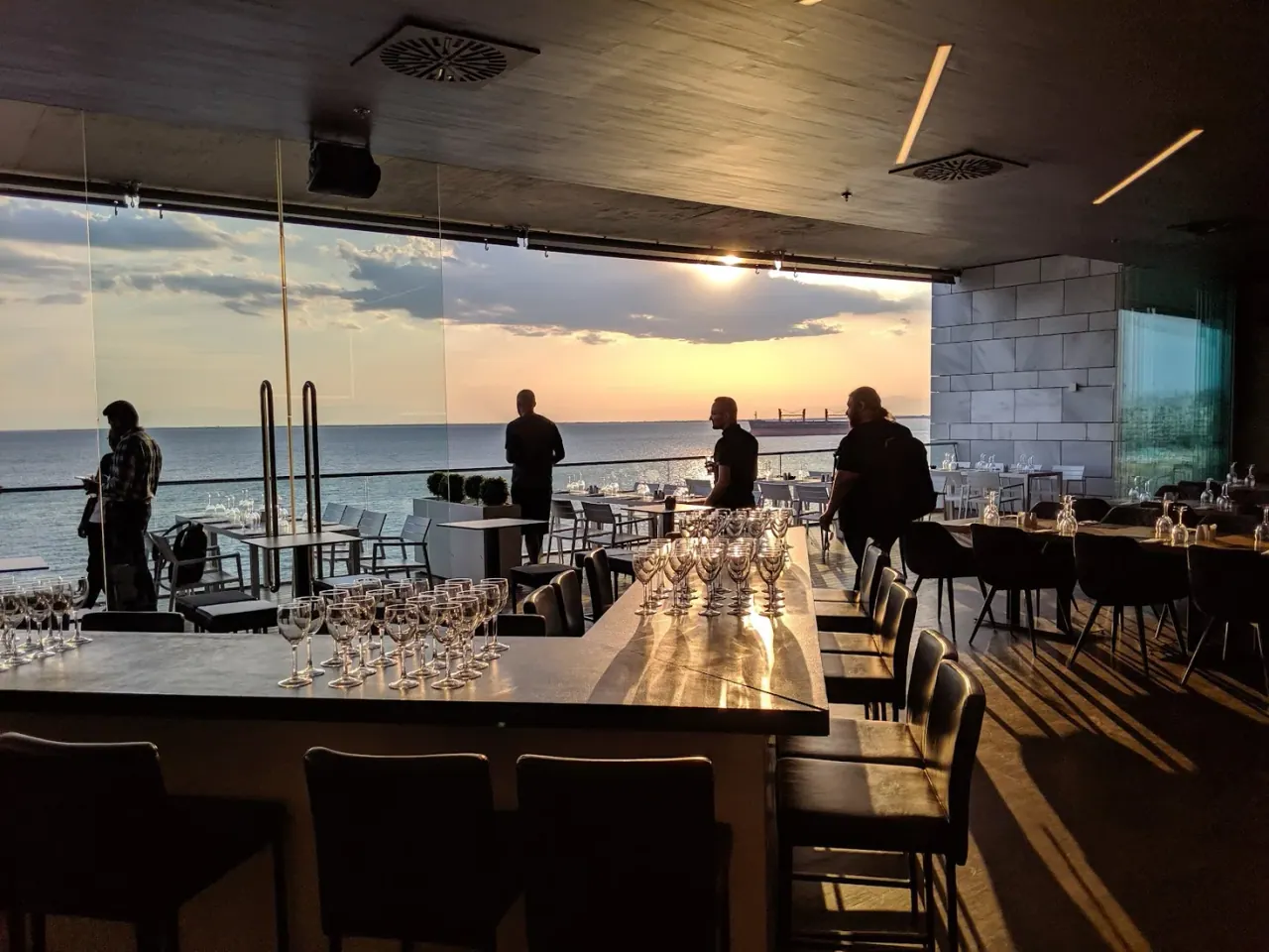 The glass-walled bar and sea-view terrace of Allegro at sunset on the Nea Paralia waterfront, Thessaloniki