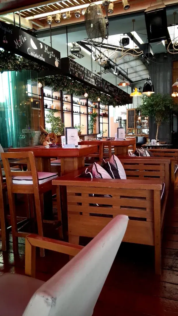 Warm wooden interior with cocktail menu boards at MeliMelo café-bar in Kalamaria, Thessaloniki
