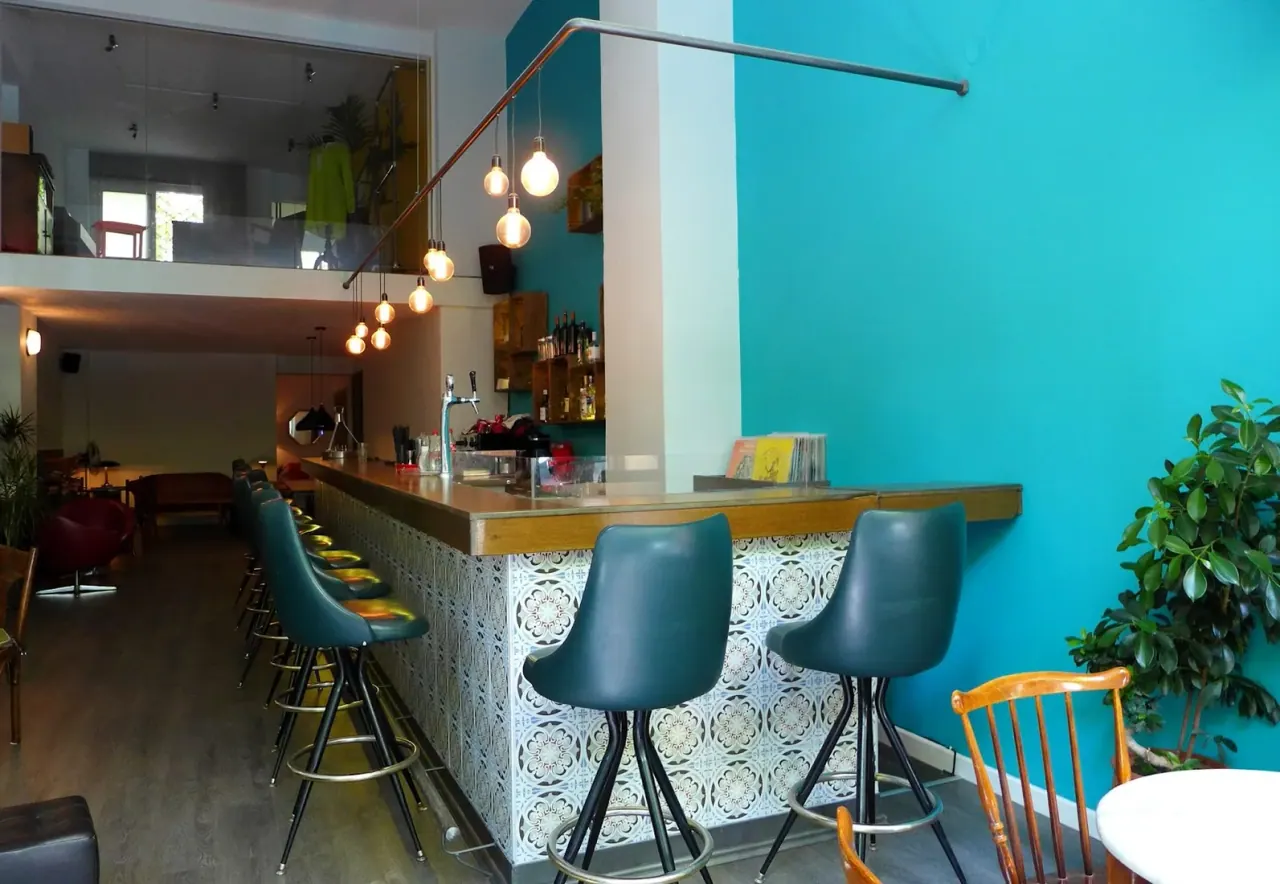 The teal-walled bar and vintage stools of To Pikap, a vinyl bar and cultural space in Thessaloniki